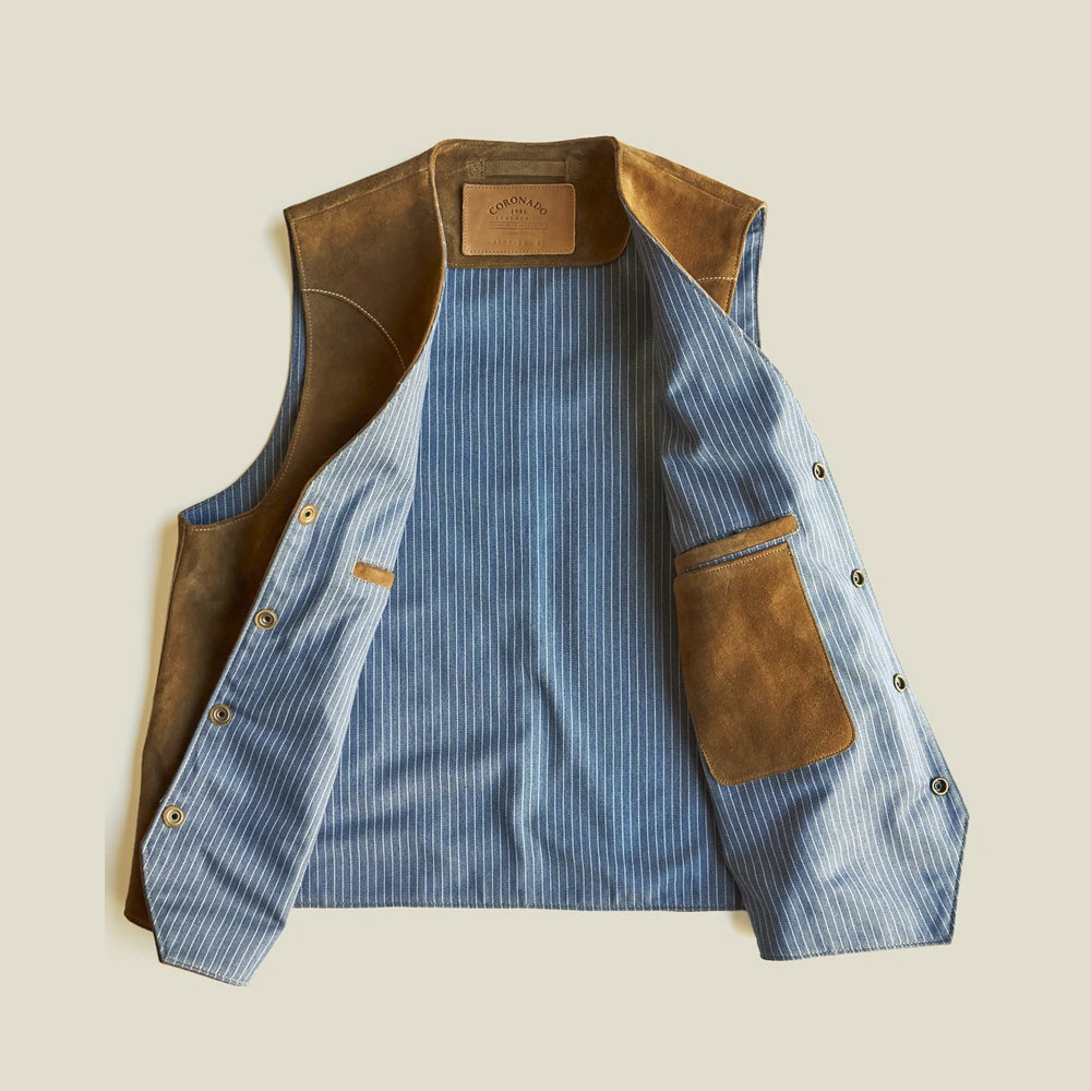 Open interior view of the suede vest showing blue striped chambray lining, leather facings and two storage pockets