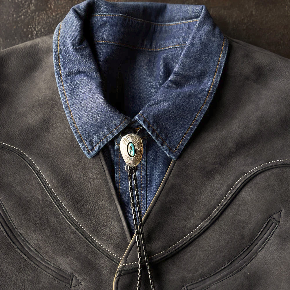 Detailed V-neck view of the charcoal cowboy vest styled with a denim collar and turquoise bolo tie