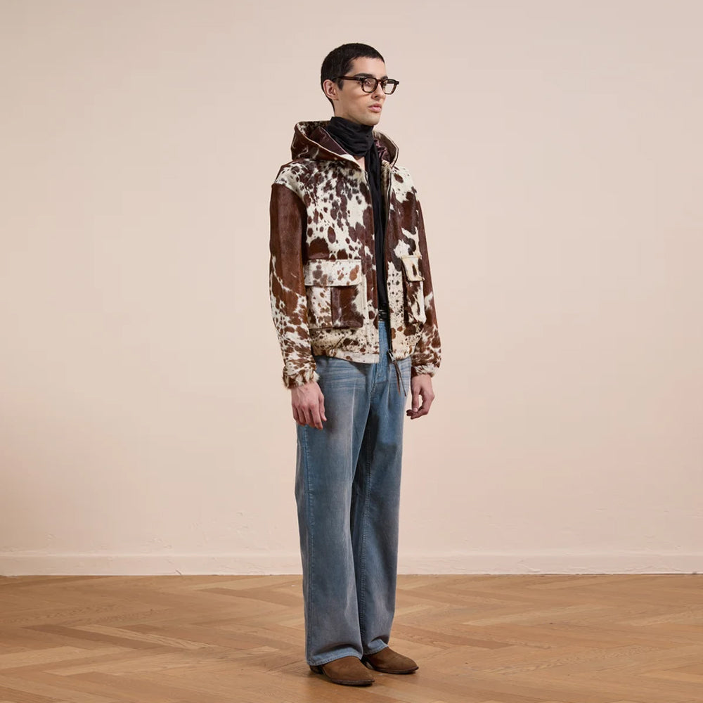 Three-quarter model view of the genuine cowhide hooded utility jacket with antique-brass zipper and cargo pockets