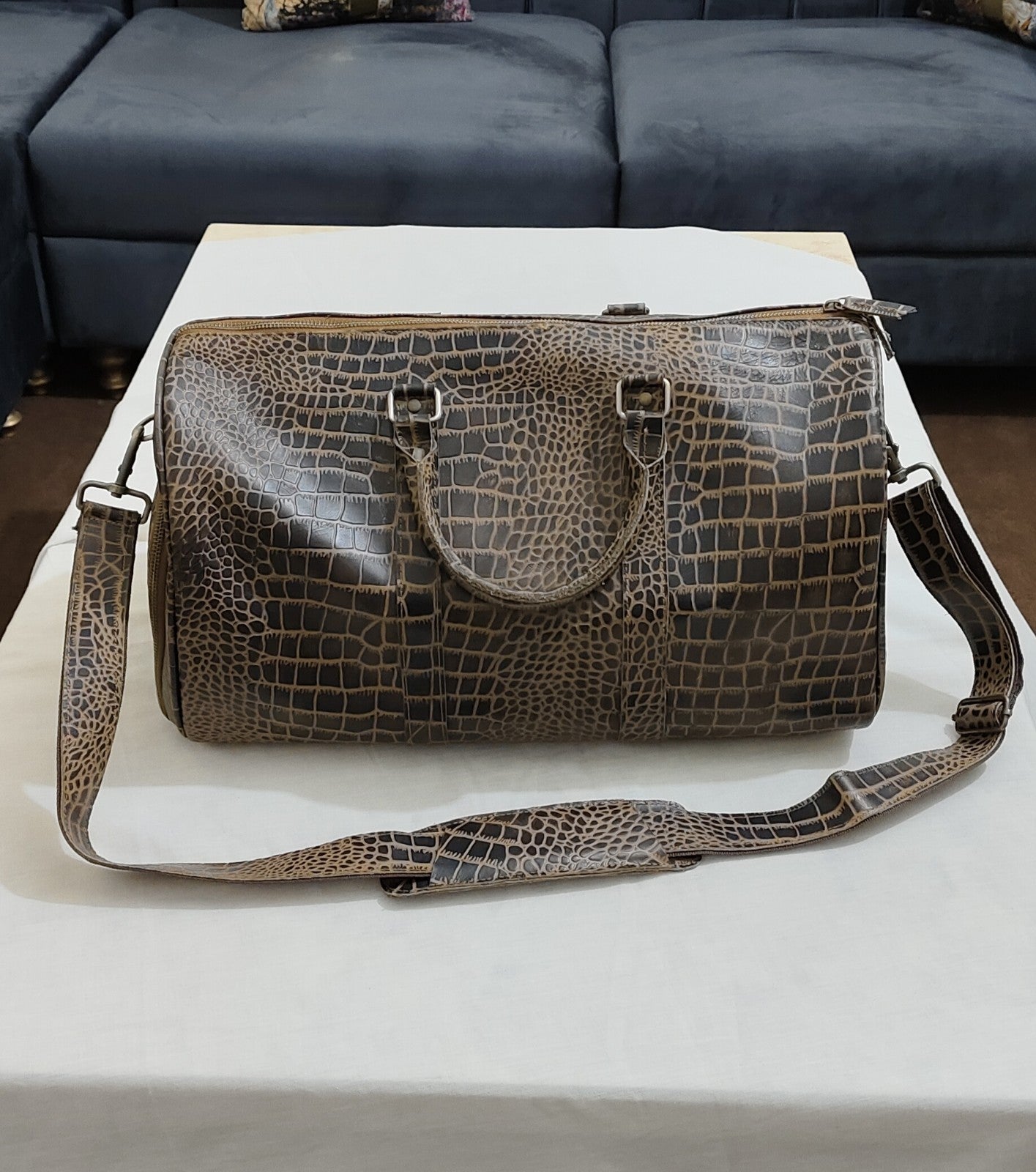 Premium croc leather travel bag packed for a weekend trip, illustrating universal carry-on size