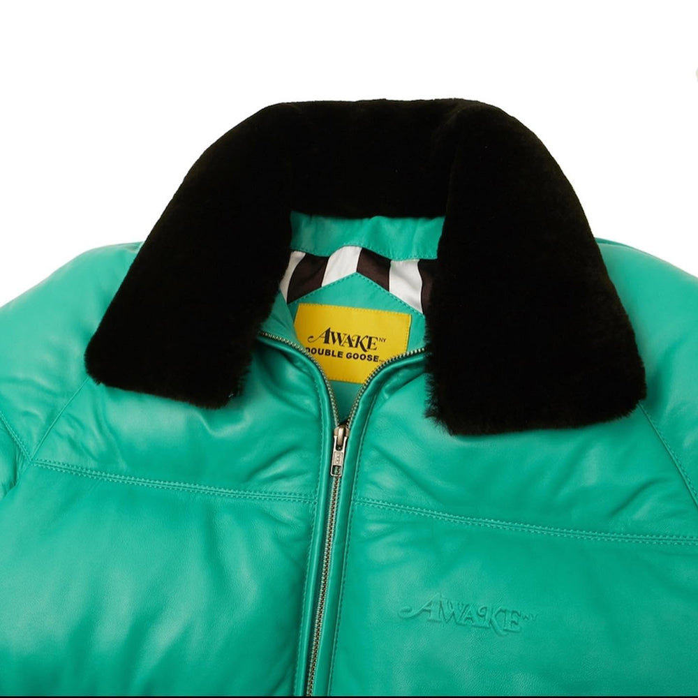 Close-up of AWAKE embossed chest logo and Double Goose collar tag on mint green leather jacket