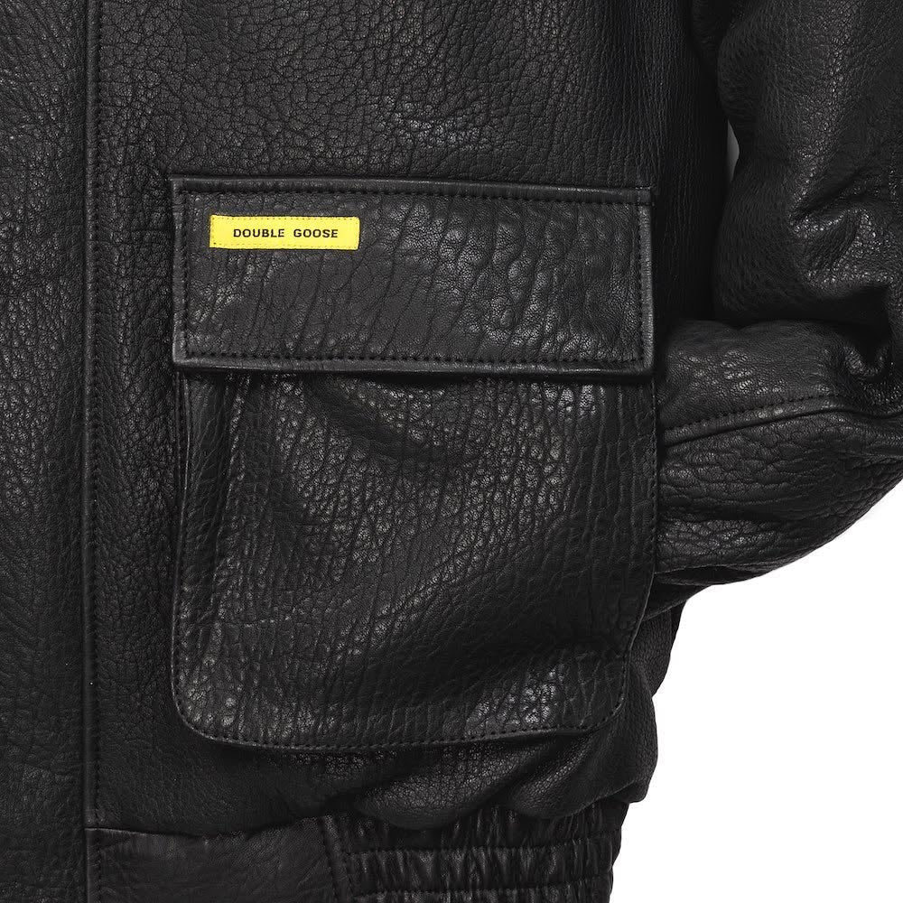Close-up of Double Goose black leather flight jacket cargo pocket with brand tab and elasticated cuff