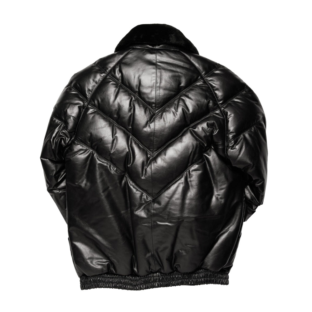 Back profile of black leather V-bomber down coat displaying downward chevron quilting and gathered elastic waistband.