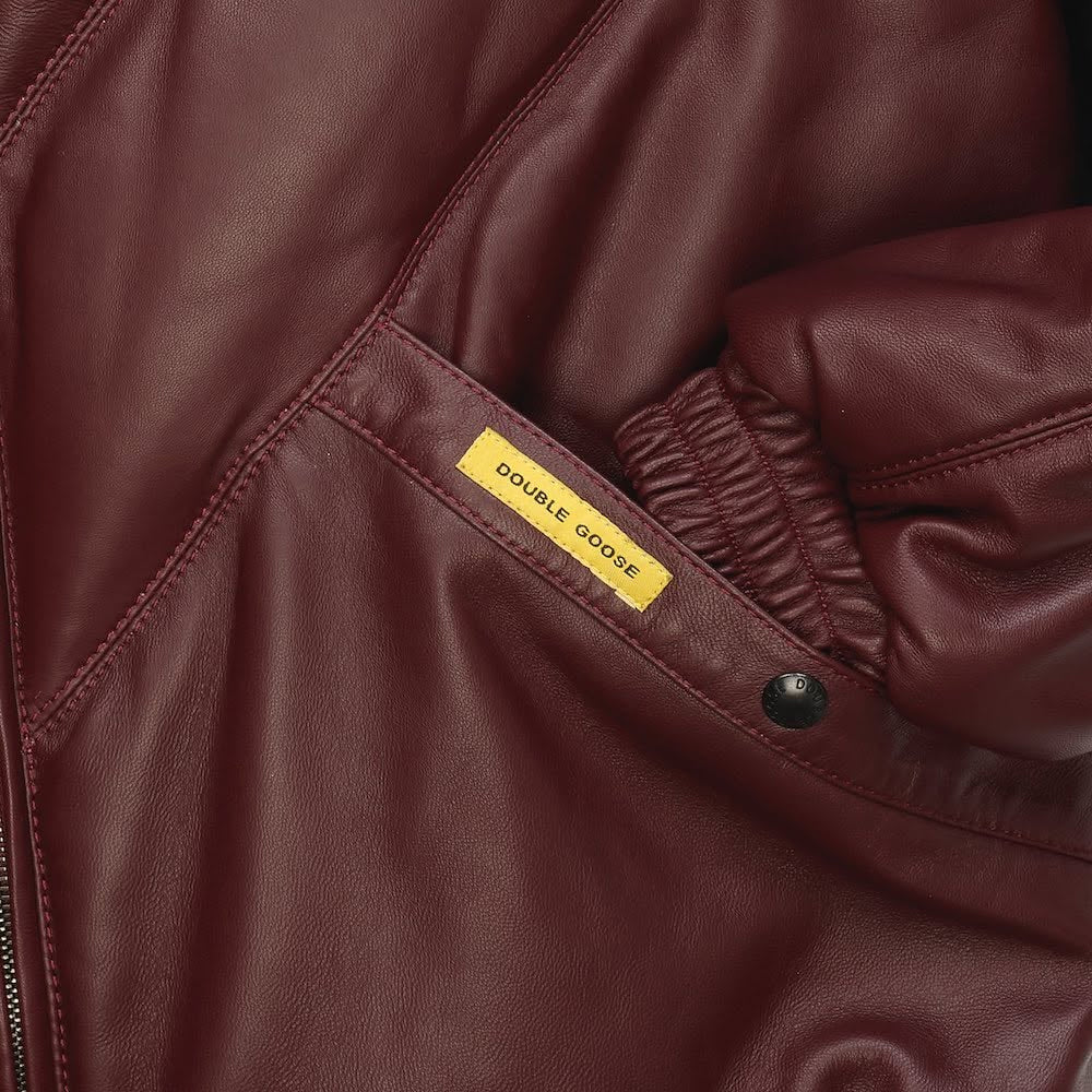 Close-up of Double Goose burgundy leather jacket pocket with woven brand tab