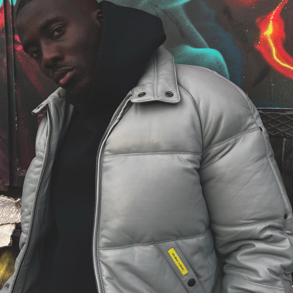 Close-up of a man wearing the original Double Goose down leather jacket, showing the light grey shell and collar