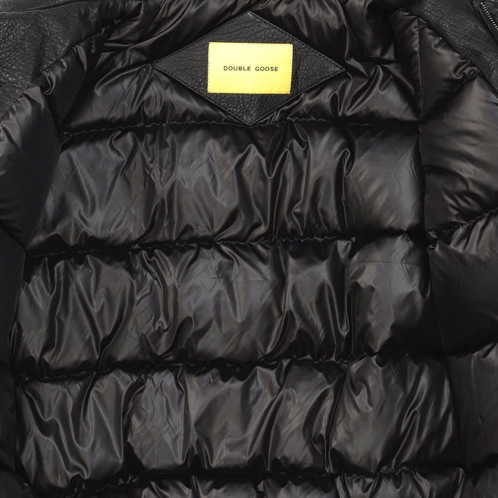 Close-up of Double Goose quilted down lining with woven brand tag inside black leather flight jacket