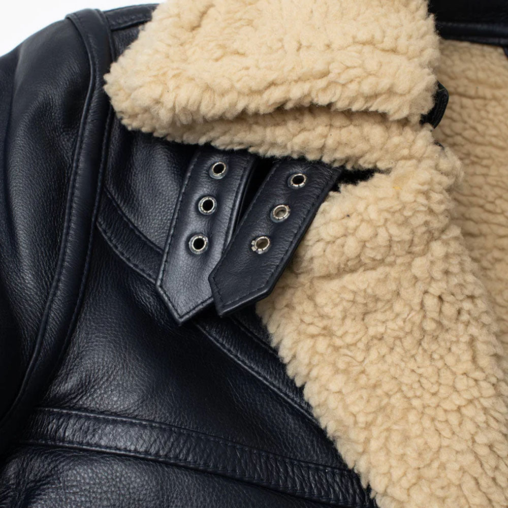 Detailed shot of dual leather neck straps with metal eyelets and buckles attached to a thick beige shearling collar