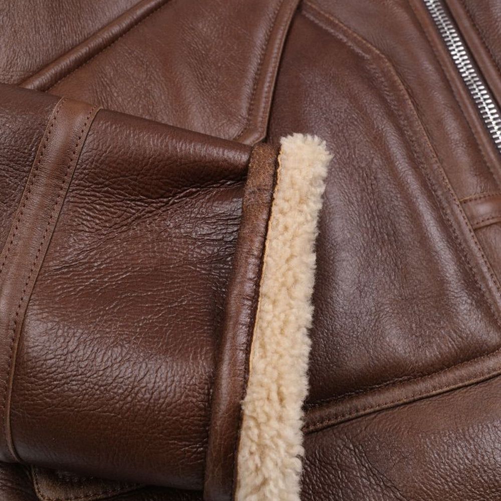 Close-up of espresso brown pebbled lambskin leather grain texture with turned-back cream shearling cuff