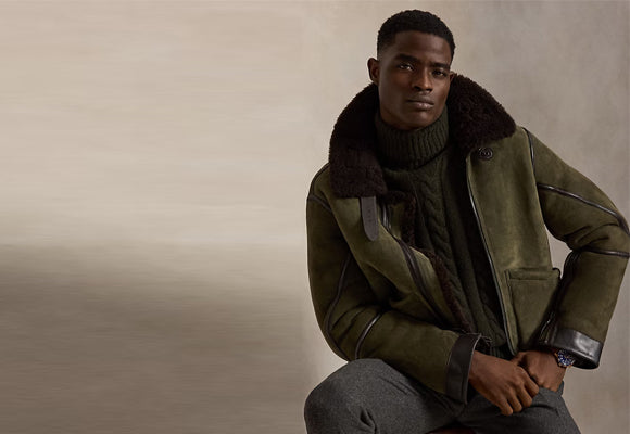 Man wearing genuine olive green sheepskin leather jacket with brown shearling fur collar - premium real leather craftsmanship