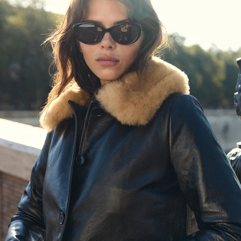Close-up of genuine tan shearling collar against naturally grained black full-grain cow leather