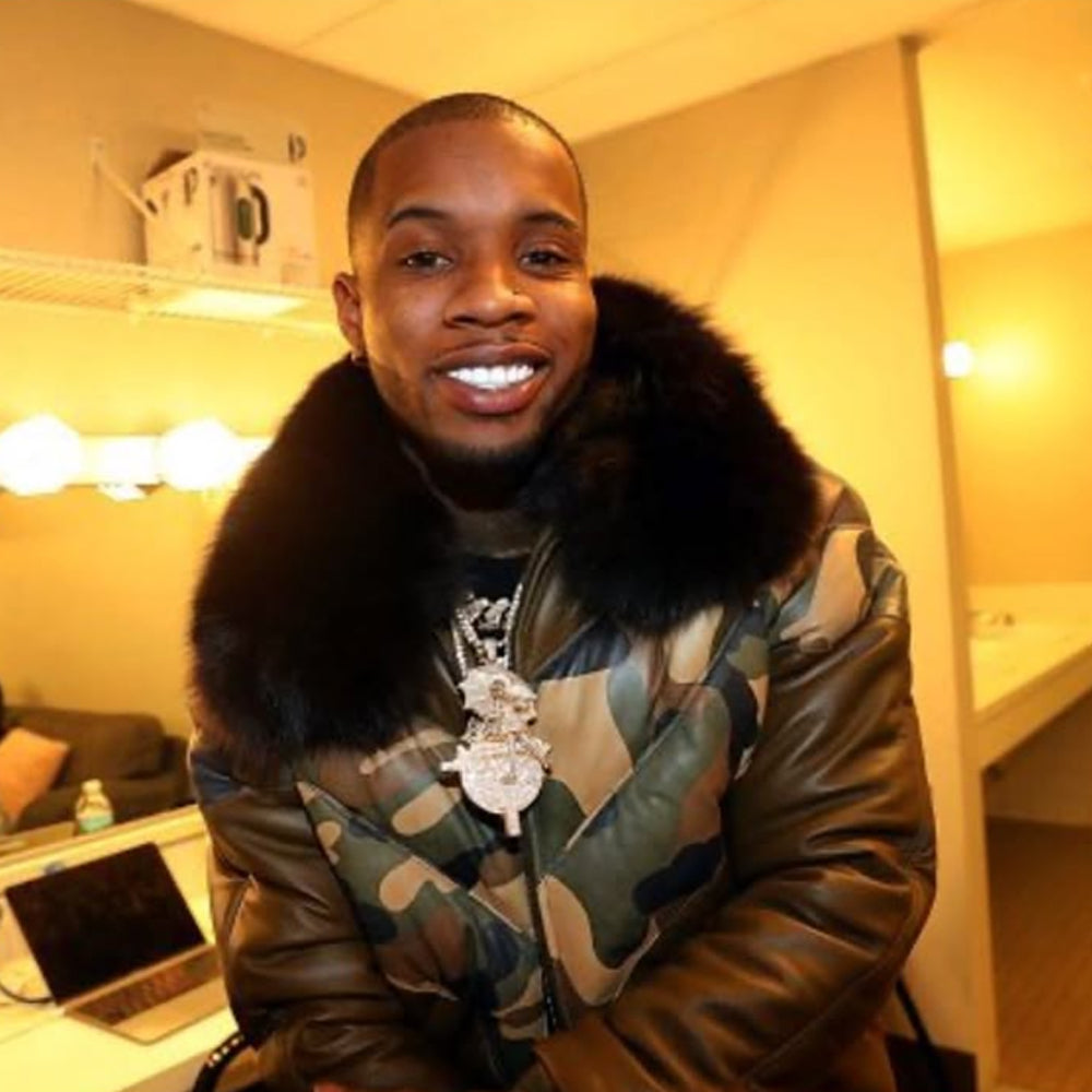 Close-up of man wearing camo leather jacket with plush black fox fur collar
