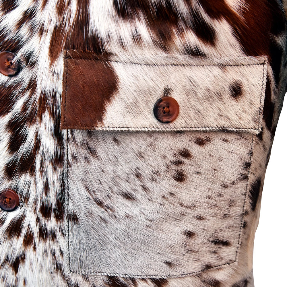 Close-up of the oversized flap patch pocket and marbled brown button on a spotted hair-on cowhide jacket