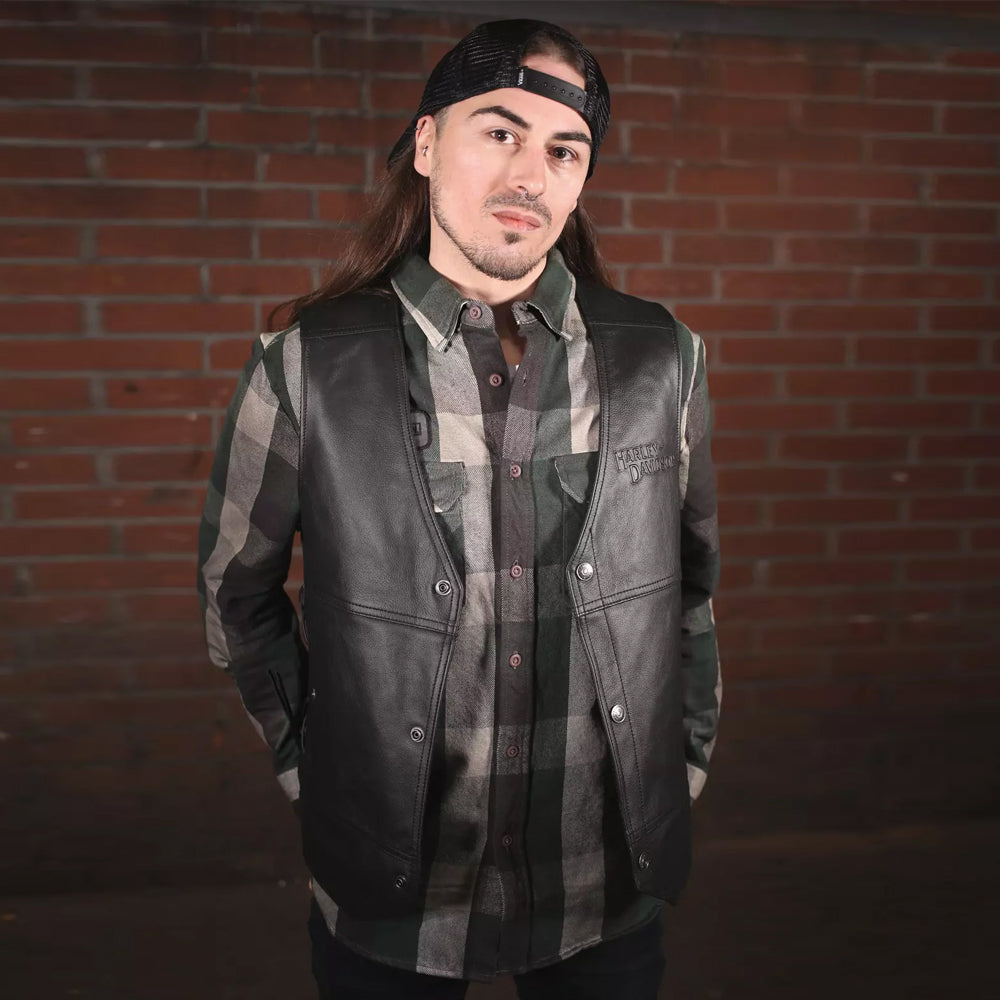 Rider wearing Harley-Davidson Tradition II vest over green shirt.