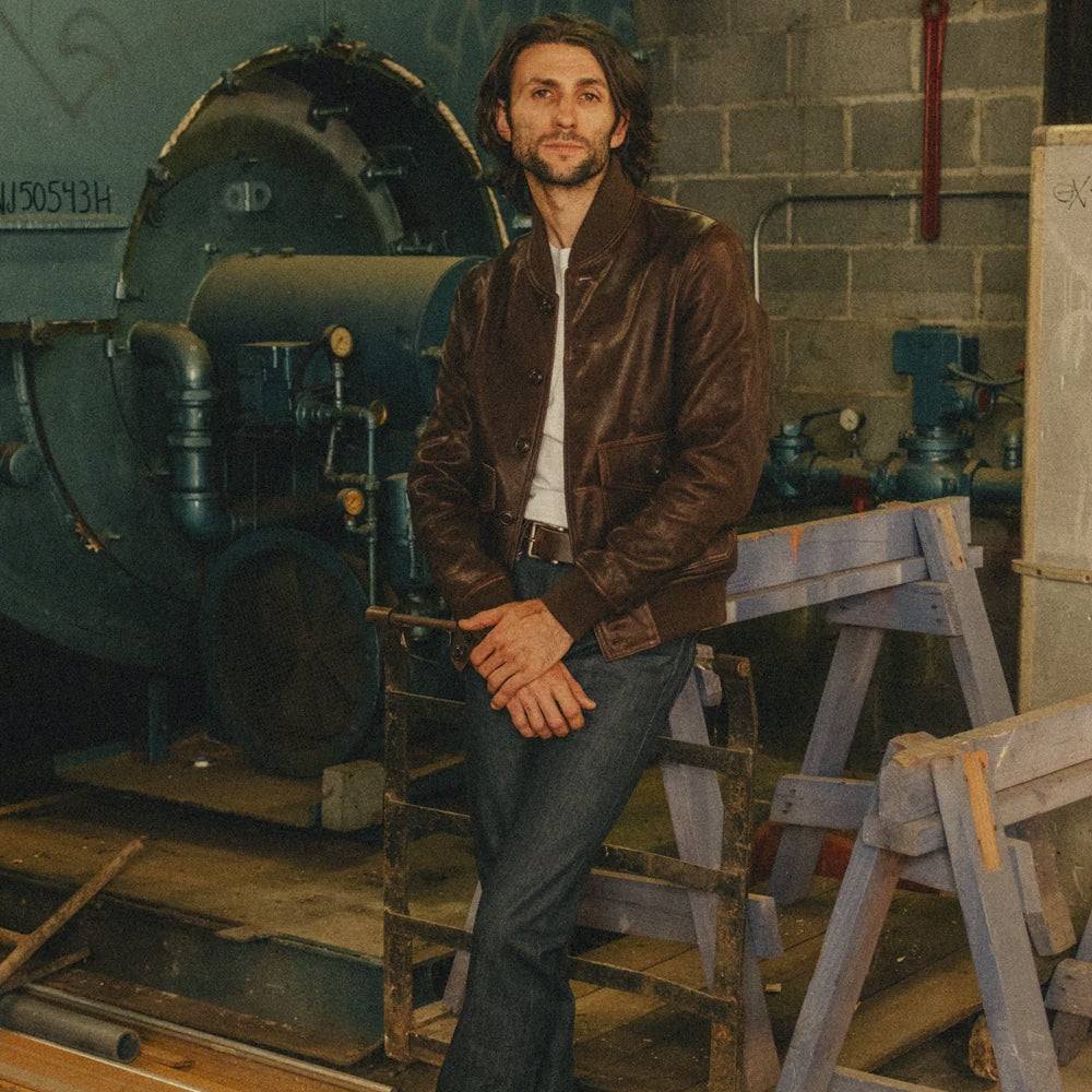 Full-body workshop styling of the heritage lambskin A-1 bomber paired with a white shirt and dark denim