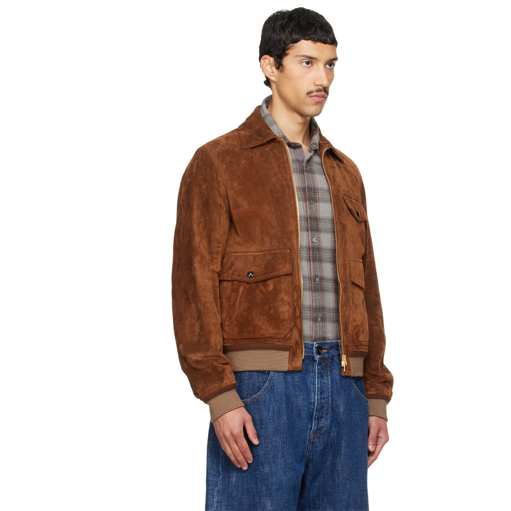 Three-quarter side view of Italian tobacco suede bomber showing its slightly relaxed fit, flap pockets and ribbed hem.