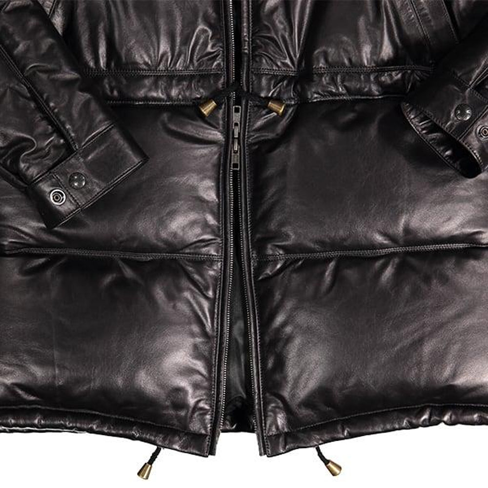 Close-up of leather down parka hem showing YKK zipper and brass-tipped drawcords