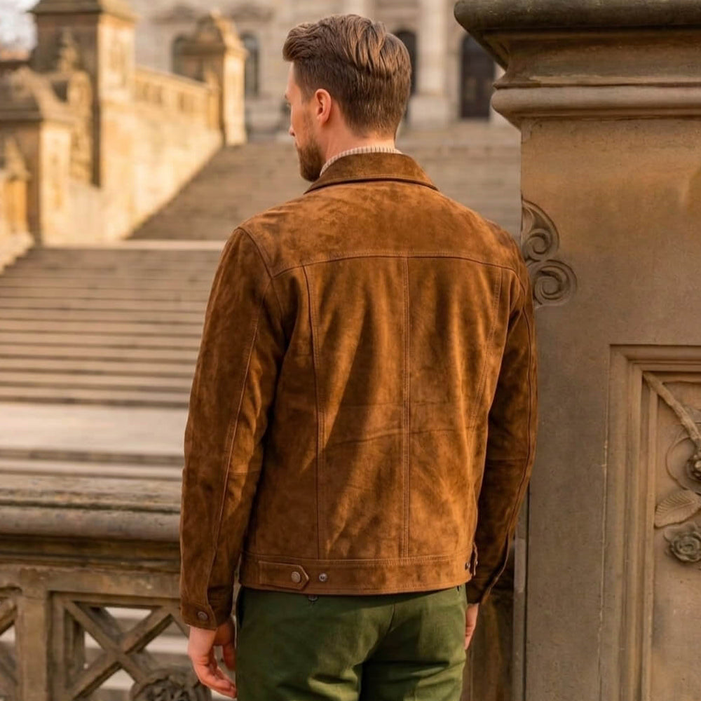 Rear view of a male model wearing a premium brown genuine suede leather trucker jacket showing the seamless back panel and fit.
