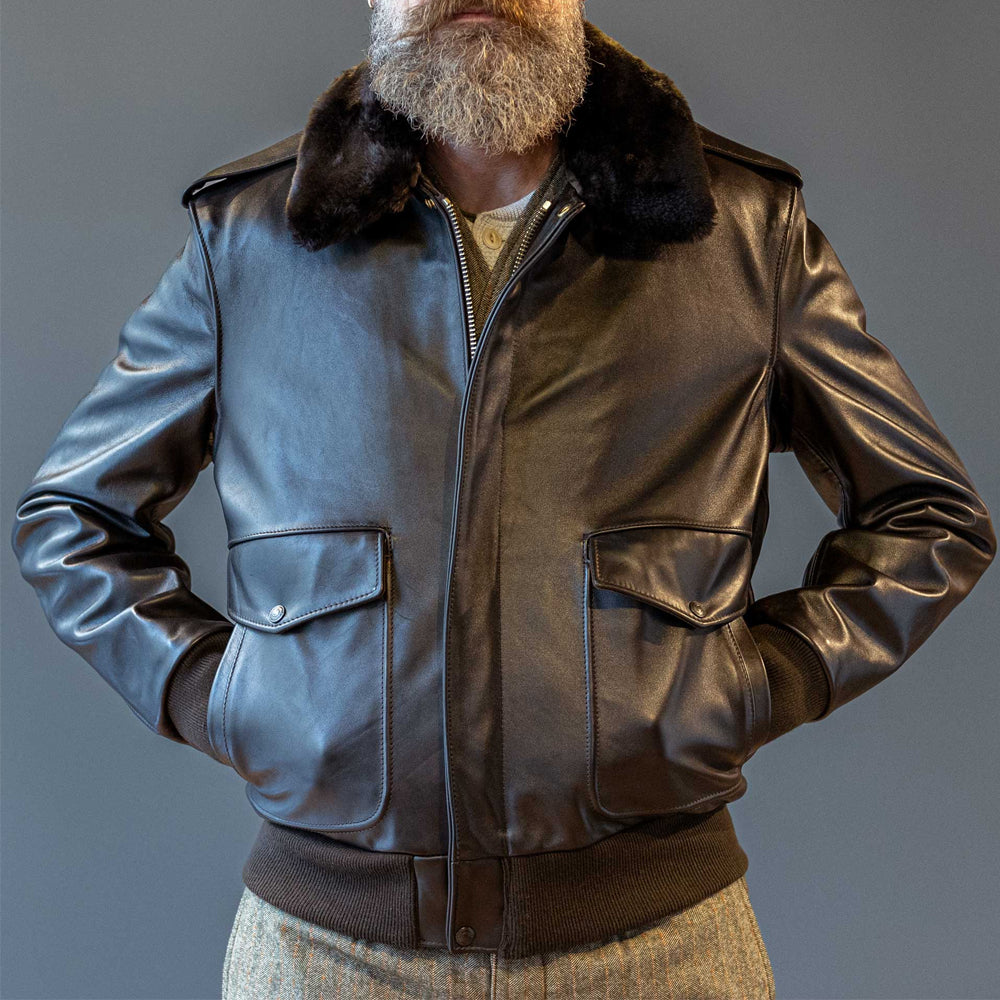 Front view of model demonstrating side-entry handwarmer slot pockets on dark brown A-2 G-1 leather bomber jacket.