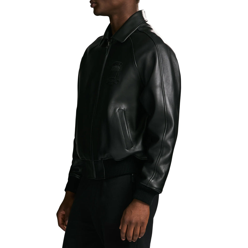 Side profile of men’s black Avirex flight-inspired bomber highlighting curved shoulder seam, welt pocket and knit cuff