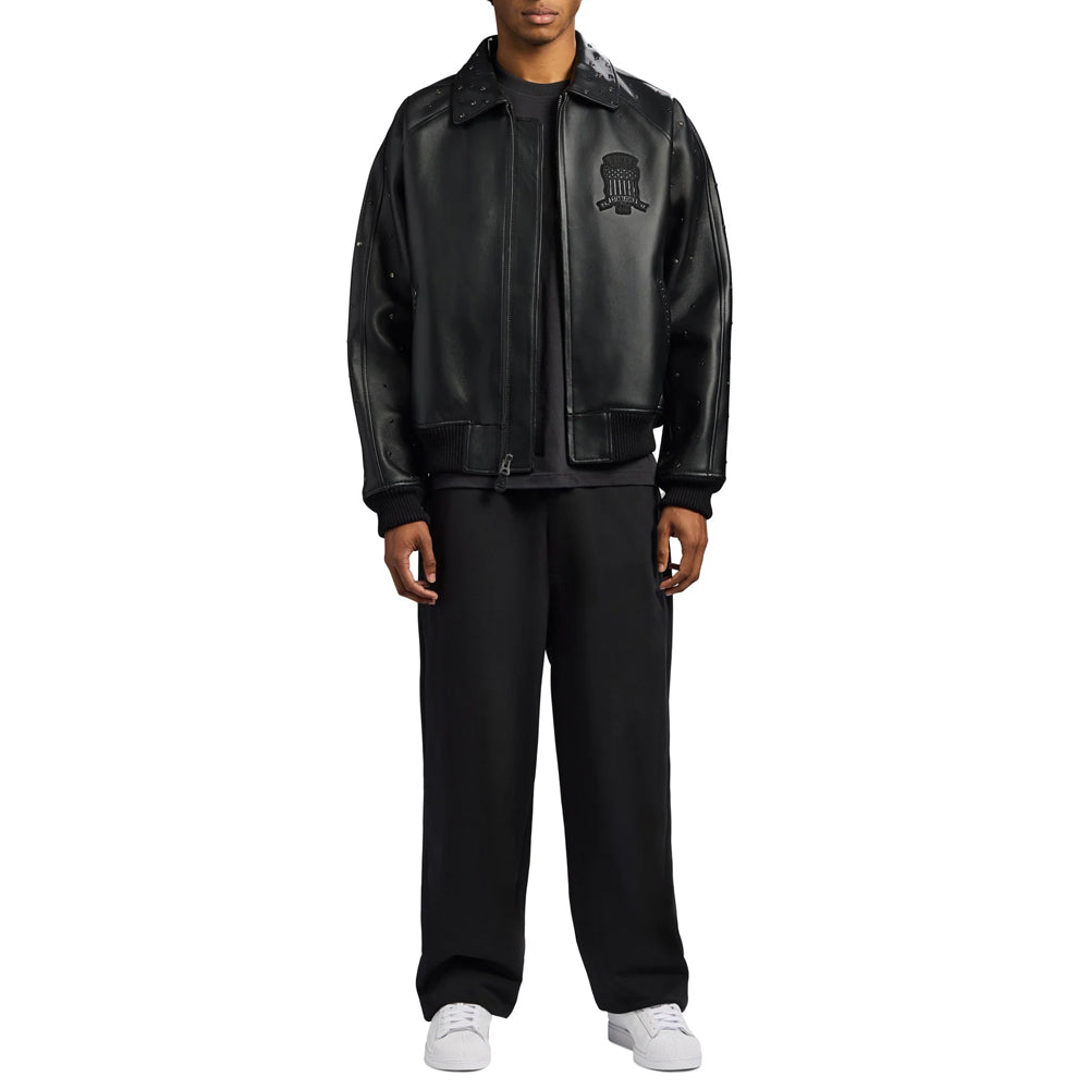 Full-length model styling the men’s Avirex black studded bomber with wide trousers and white sneakers