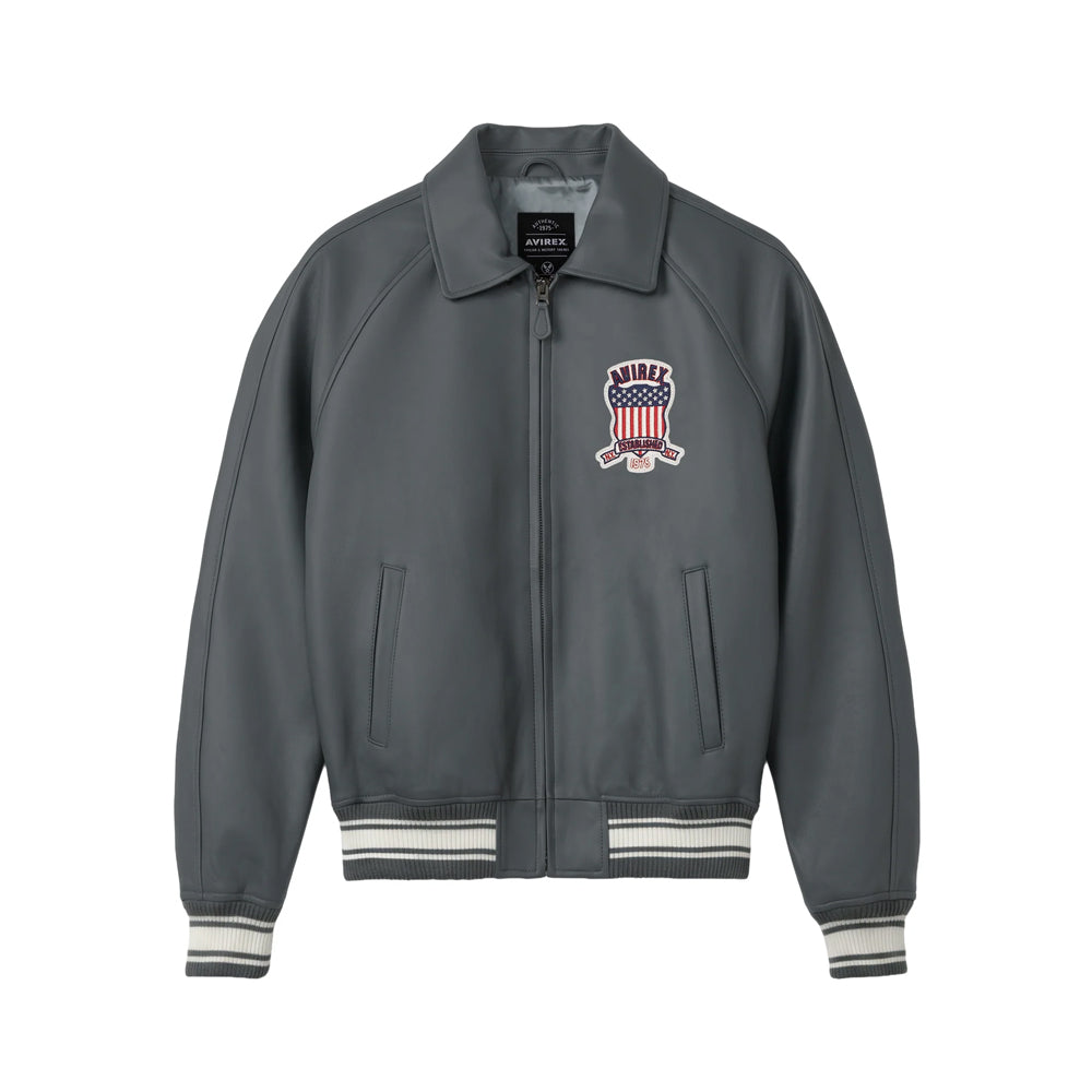 Front view of men’s Avirex gray Icon lamb leather bomber with patriotic chest crest, point collar and striped rib trim