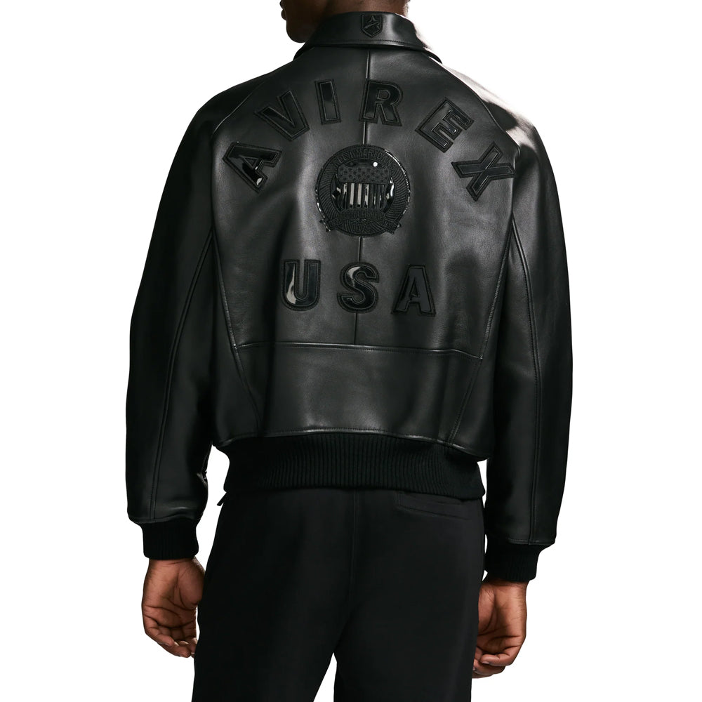 Rear model view of men’s Avirex Iconic black bomber showing tonal USA lettering, central emblem and upper-hip hem