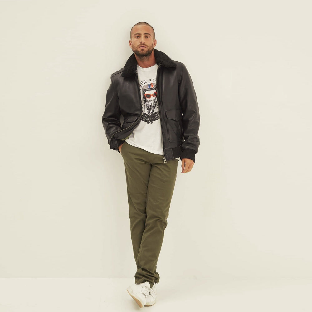 Full-length styling view of men's black leather aviator bomber with tonal shearling collar, metal zipper and rib-knit hem.