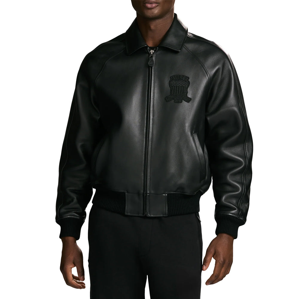 Male model wearing men’s black Avirex lambskin bomber with center zipper, angled welt pockets and relaxed sleeves
