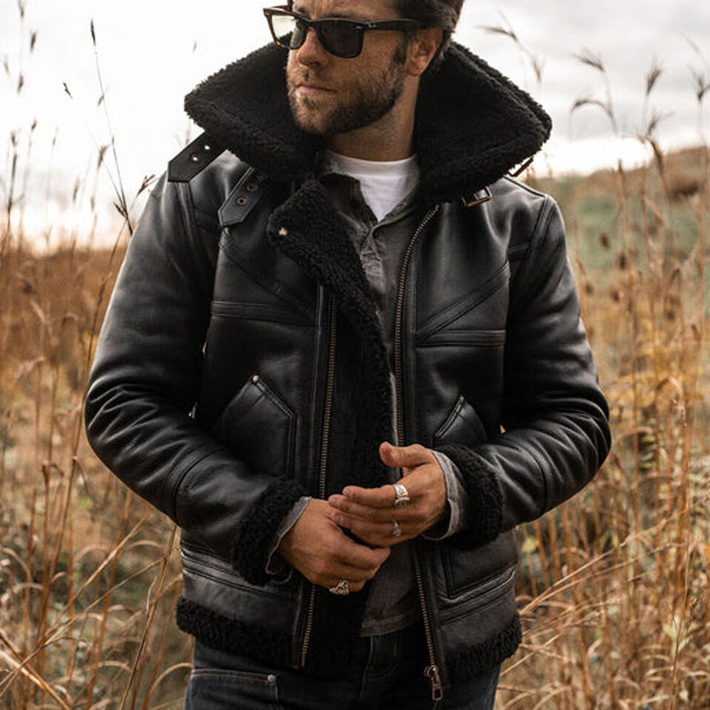 Medium shot of model wearing unzipped men's black B3 aviator flight jacket displaying wide black shearling spread collar and black fleece lining