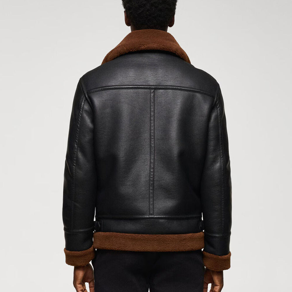 Back view of model wearing men's jet black B3 aviator shearling jacket showing horizontal shoulder yoke and brown fur hem trim
