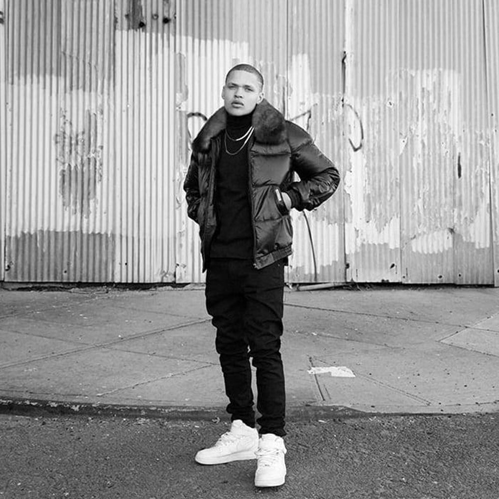 Man wearing black leather Country Down jacket with shearling collar on urban street