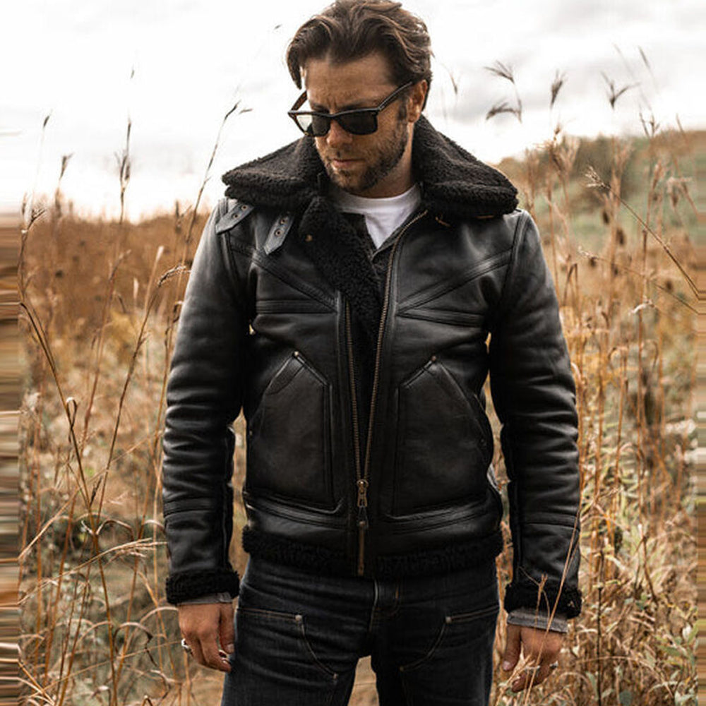 Model wearing men's black shearling B3 bomber jacket with sunglasses standing in outdoor field