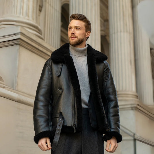 Male model wearing a men’s black shearling flight jacket with oversized collar and adjustable leather waist belt