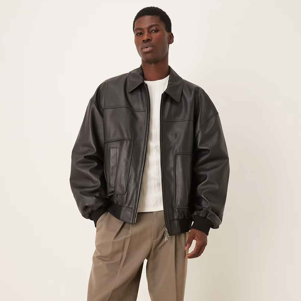 Male model wearing boxy Oil Black leather flight bomber with full sleeves and waist-level knitted hem