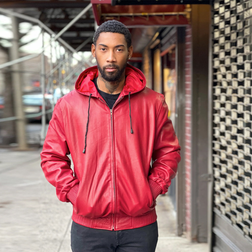 Men’s bright red leather hoodie shown with the fixed hood down, smooth shell, matching red satin interior and ribbed waistband.