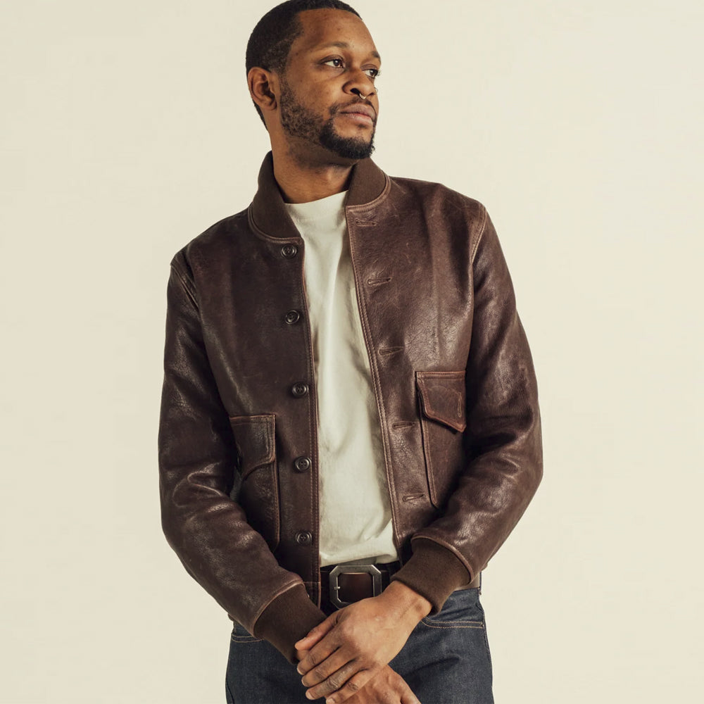 Studio model wearing the men’s brown button-front flight jacket with compact rib trims and regular waist-length fit
