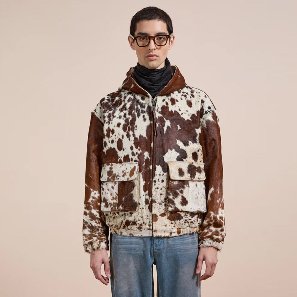 Front view of a man wearing the brown and cream hair-on cowhide hooded jacket with two snap flap pockets