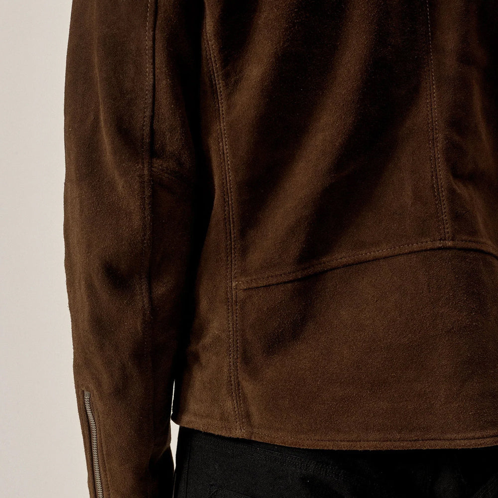 Close-up of tobacco brown suede texture with rear panel seams and zippered cuff