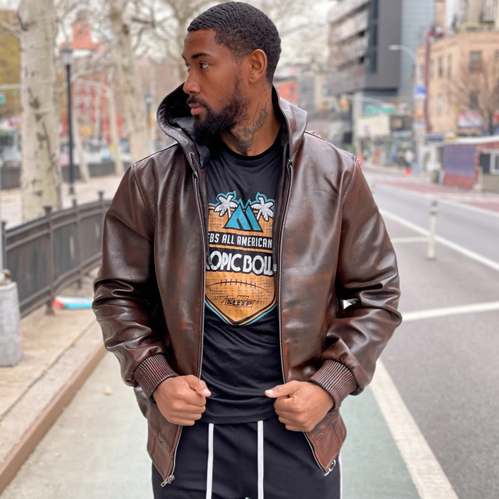 Men’s burnished chocolate-brown leather hoodie worn open, showing the black satin hood interior, shaped sleeves and rib-knit waistband.