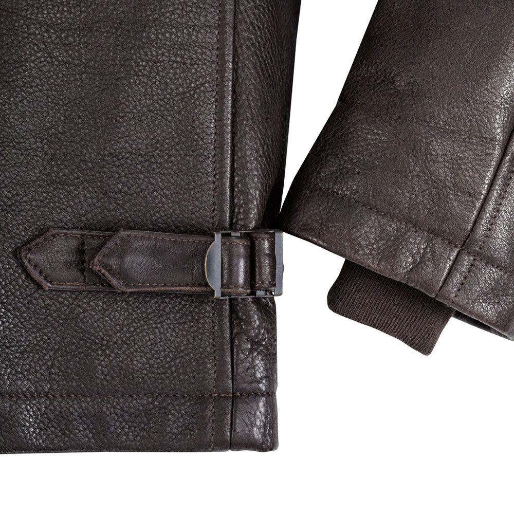 Detailed close-up shot of dark brown deer-tanned calfskin texture and waist strap buckle.