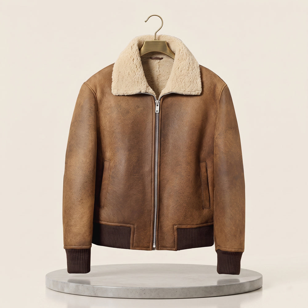Front view of men's distressed camel tan sheepskin flight jacket featuring broad cream shearling shirt collar and dark brown ribbed hemband.