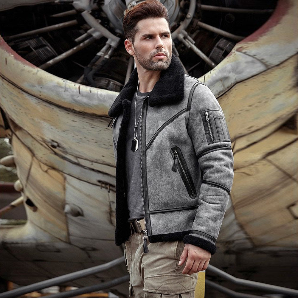 Three-quarter view of men’s charcoal sheepskin flight bomber showing black shearling collar and sleeve utility pocket