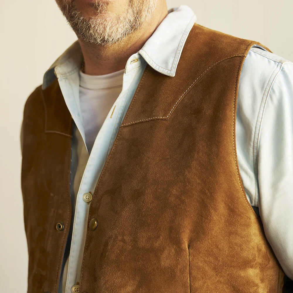 Upper-body view showing the collarless V-neck opening and shaped shoulder yokes of the men’s suede waistcoat
