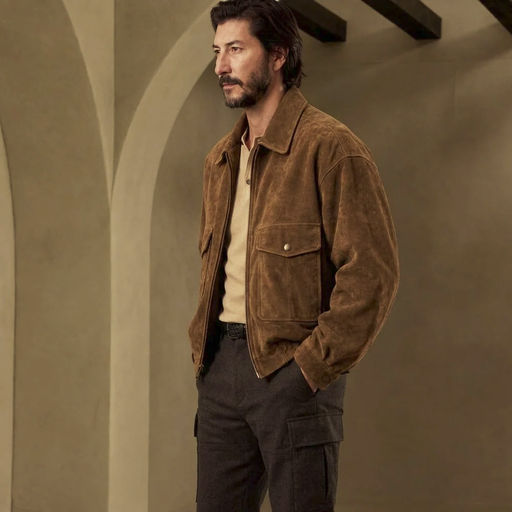 Side profile of men’s cowhide suede trucker jacket with tobacco nap, structured collar, lower hand access and snap cuff.