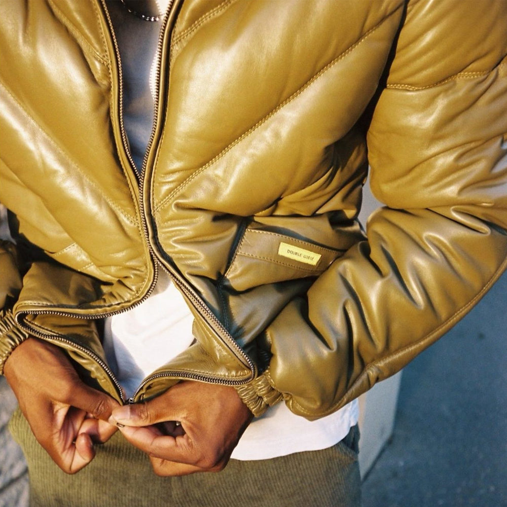 Man wearing the original Double Goose down leather jacket in khaki, zipping up for street-style winter look