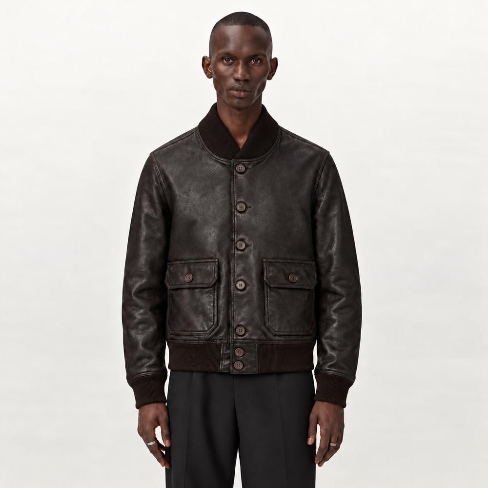 Male model wearing espresso brown A-1 lambskin bomber jacket with seven-button front, compact waist and regular fit.