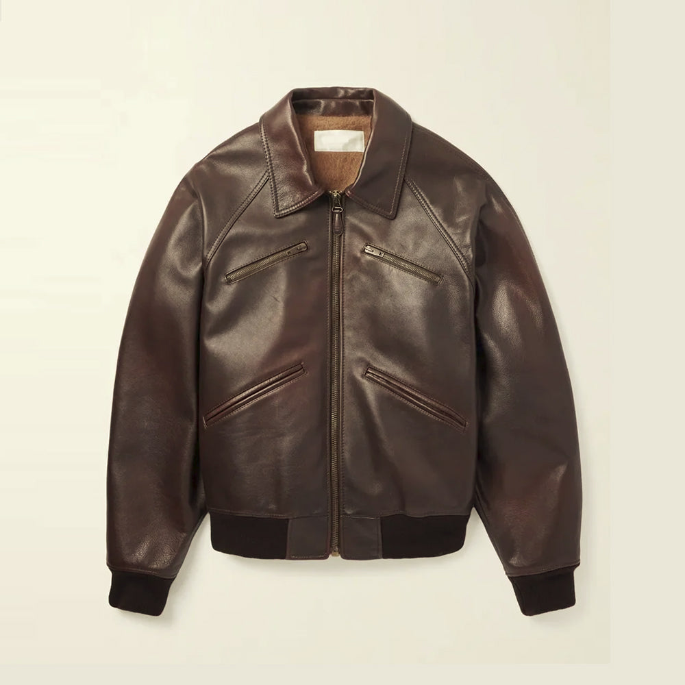 Front flat lay of a men’s brown waxed lambskin bomber jacket with raglan sleeves, point collar and four zip pockets