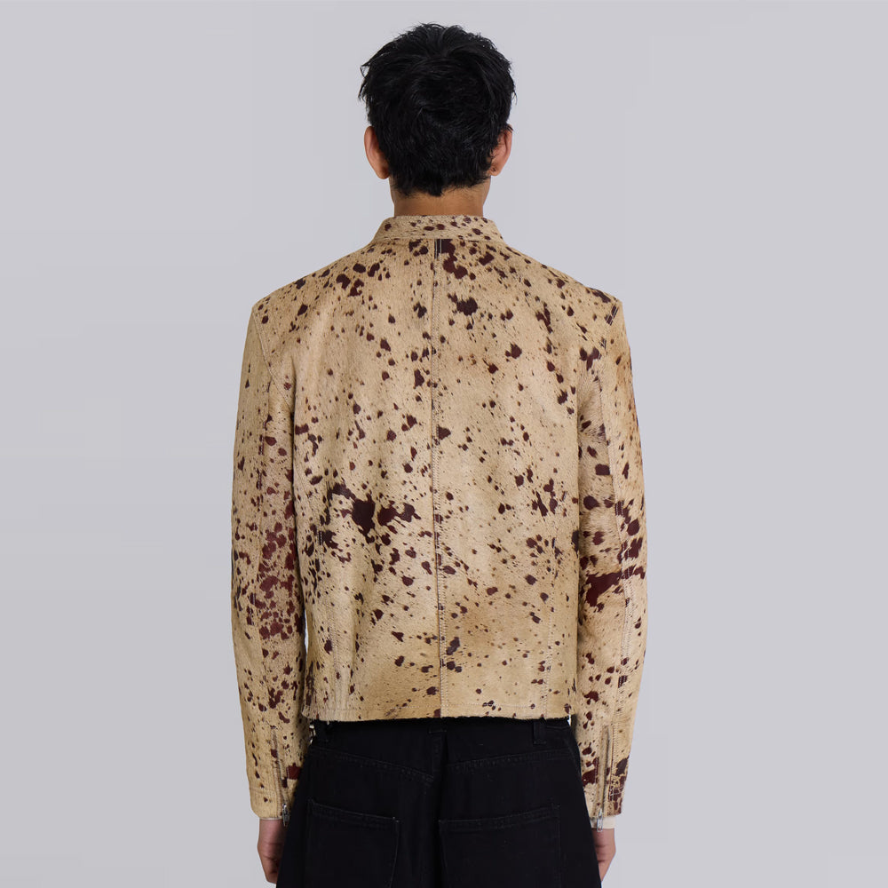 Back view of men’s tan hair-on cowhide racer jacket showing center seam and speckled panels