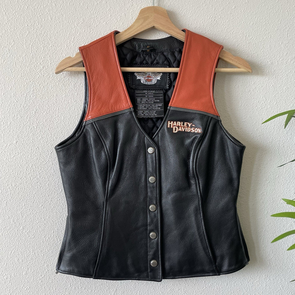 Front view of men's Harley Colorblock orange panel snap leather vest.