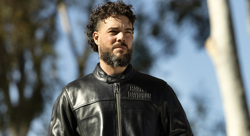 Man wearing a black Harley-Davidson cafe racer leather jacket outdoors